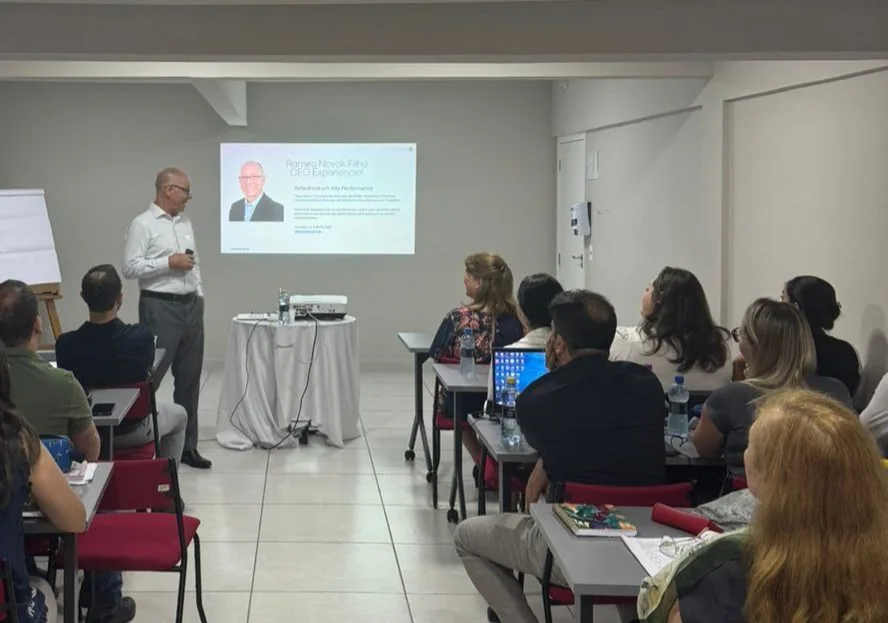 Ramiro Novak Filho conduzindo um encontro para uma turma sentada em mesas